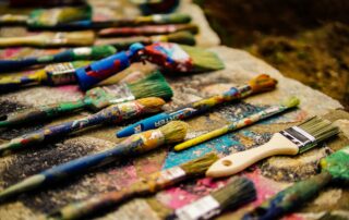 a lot of paint brushes on ground