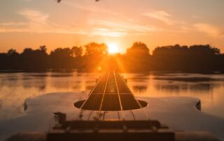 silhouette of person sitting on dock during sunset