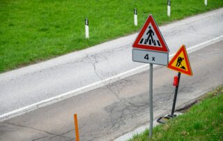 two road signs beside green grass