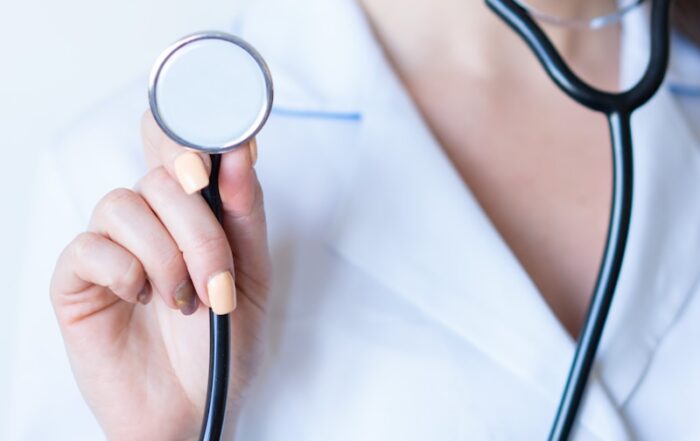 a woman in a white shirt holding a stethoscope