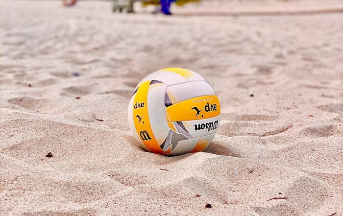 yellow and white volleyball on white sand during daytime
